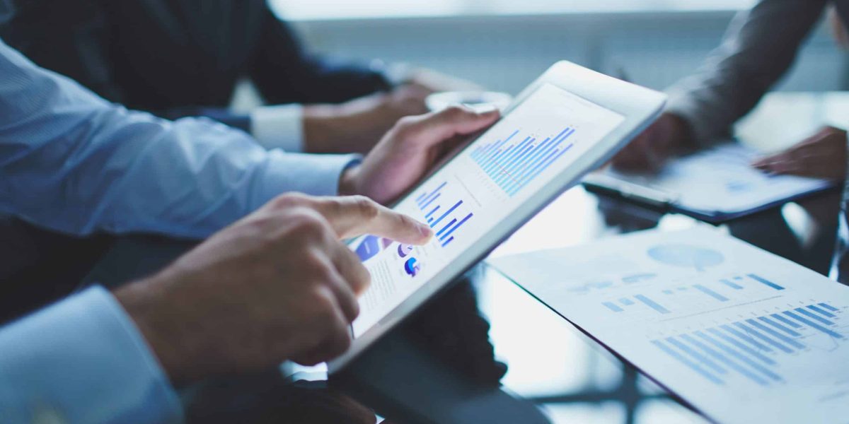 Image of businessperson pointing at document in touchpad at meeting