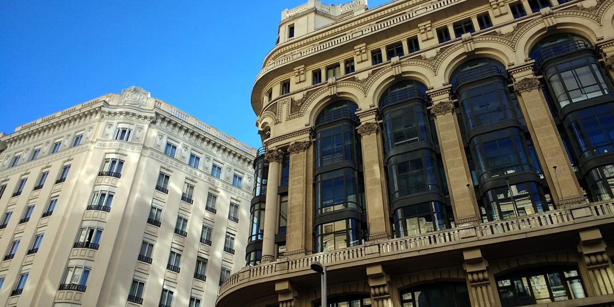 A low angle shot of buildings in Spain under a clear blue sky