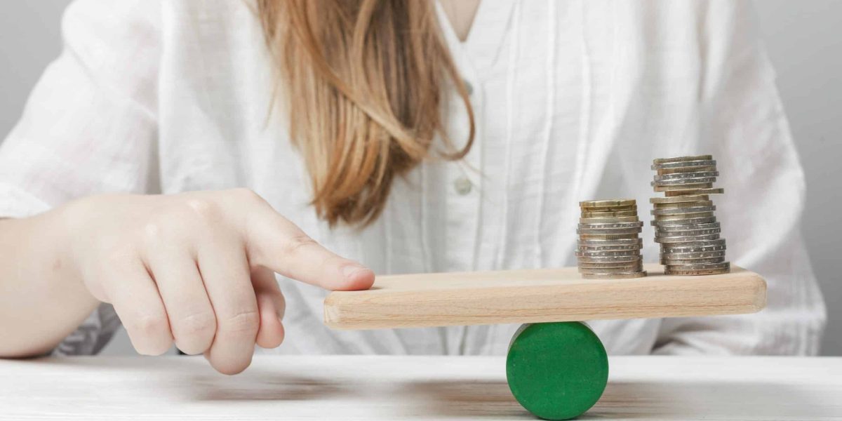 woman-holding-her-finger-balance-with-coins